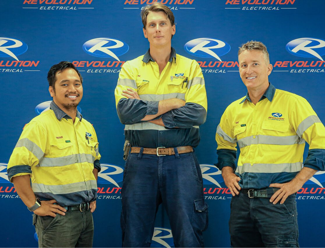 Revolution Electrical leadership team standing in front of branded backdrop, representing experience and professional electrical services.