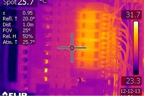 Thermal imaging scan of an electrical switchboard showing heat variations across circuit breakers and wiring during an inspection by Revolution Thermography.